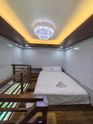 a room with a bed and a chandelier at Yurich Hotel in Romblon
