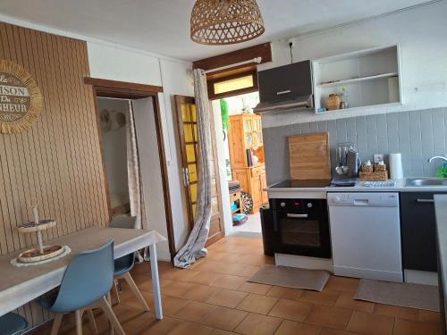 a kitchen with a counter and a table with chairs at maison village 4 chambres 30 minutes du zoo de beauval in Saint-Cyran-du-Jambot