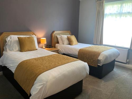 a hotel room with two beds and a window at Exeter Court Hotel in Exeter
