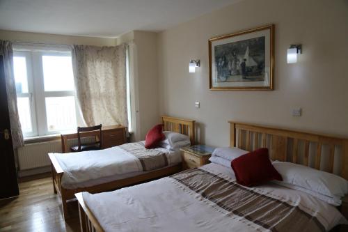 a hotel room with two beds and a window at All Seasons Guest House in Oxford
