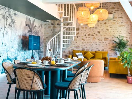 une salle à manger avec une table, des chaises et un canapé dans l'établissement Le Golf Comme Jardin Dormez au Cœur du Parcours, à Lésigny