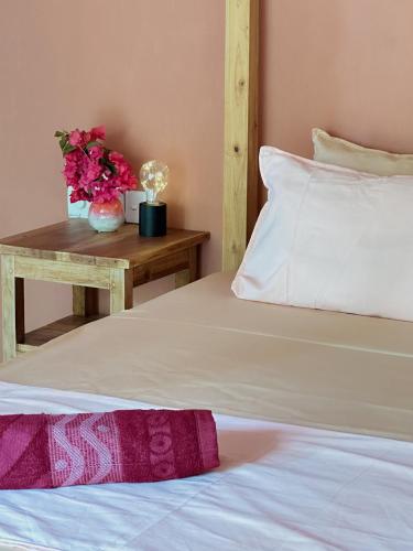 a bedroom with a bed and a table with flowers at Villa Arugam Bay in Arugam Bay