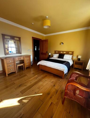 a bedroom with a bed and wooden floors at Yewwood Cottage in Newry