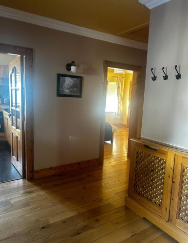 a living room with a wooden floor and two doors at Yewwood Cottage in Newry