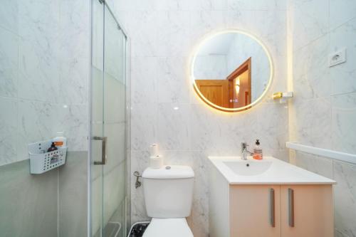 a bathroom with a toilet and a sink and a mirror at 4-Bed Villa Sleeps 8 Pets Ok & 10 min to Beach in Los Alcázares