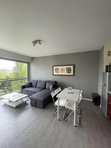 a living room with a couch and a table at Sky - Superbe appartement lumineux et cosy in Villers-sur-Mer