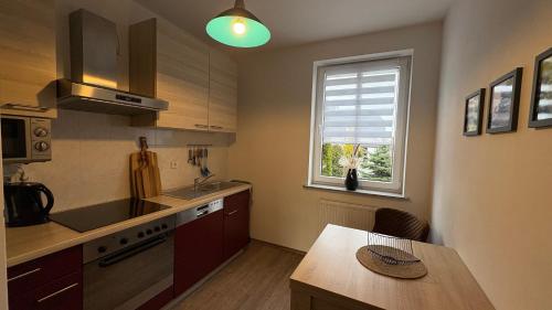 a kitchen with a sink and a table and a window at Ferienwohnung Fürstenberg - Storch in Fürstenberg-Havel