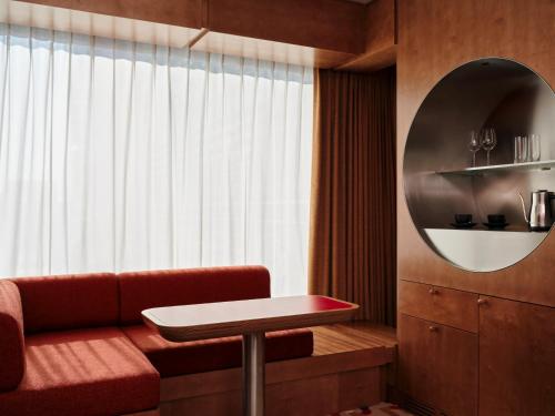 a living room with a red couch and a mirror at The Standard, Brussels in Brussels