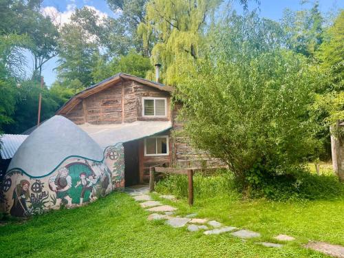 a house with a painting on the side of it at Casitas del arroyo Actividades Arte Cultura y descanso en Villa General Belgrano in Villa General Belgrano
