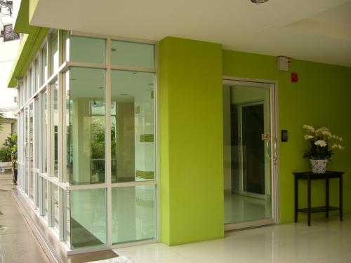 a green wall with glass doors in a building at 181 Ekkamai Apartment in Bangkok