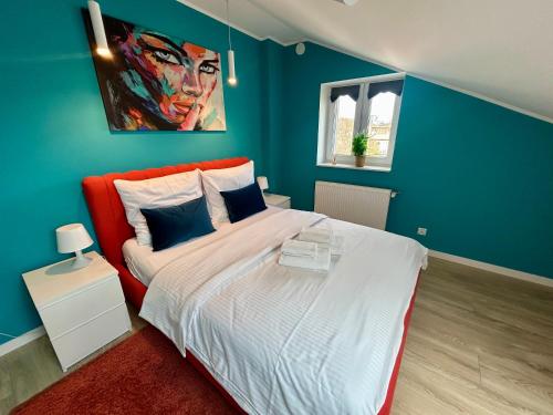 a bedroom with a large bed with blue walls at Apartment Targowa L15 in Lublin