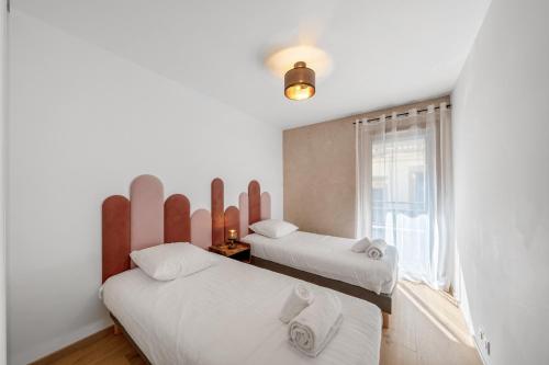 une chambre avec deux lits et une fenêtre dans l'établissement Appartment hypercentre Evian, à Évian-les-Bains