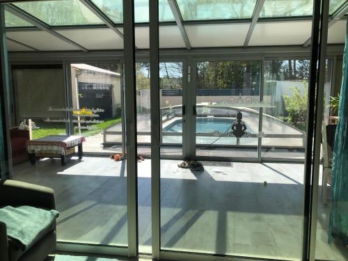vue d'une piscine depuis l'intérieur d'une maison dans l'établissement La perle, aux Mathes