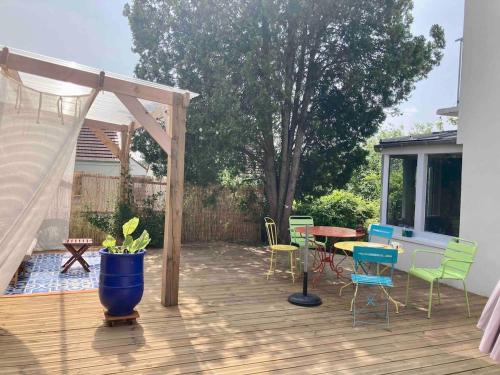 a patio with a table and chairs on a deck at La cabane, Chambre indépendante dans jardin - Esprit cabane authentique et confortable - la campagne à 5 mn du centre de Caen in Fleury-sur-Orne
