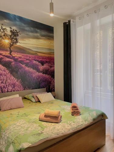 une chambre avec un lit avec un tableau sur le mur dans l'établissement L'universal Provençal au coeur de Mulhouse, à Mulhouse