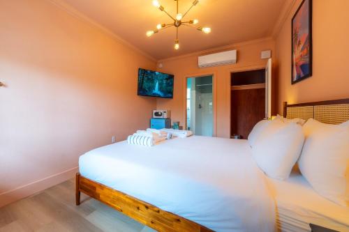 a bedroom with a white bed and a chandelier at Monaco Vacation Rentals in Clearwater Beach