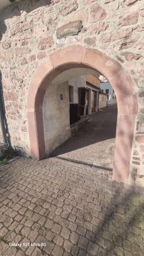 an archway in a stone building with a brick sidewalk at Amtsschreiber-Pförtchen Ferien Wohnung in Gemünden
