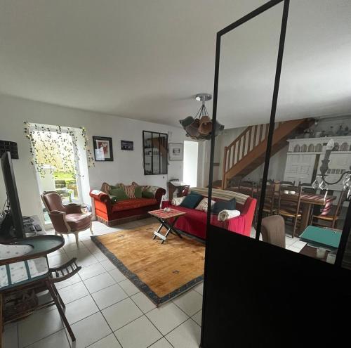 un salon avec un canapé rouge et une table dans l'établissement Maison historique - cour - centre-ville -plage 10 mn, à Pont-lʼAbbé