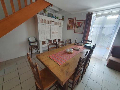 une salle à manger avec une table et des chaises en bois dans l'établissement Maison historique - cour - centre-ville -plage 10 mn, à Pont-lʼAbbé