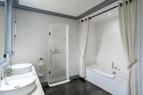 a bathroom with a tub and a sink and a shower at Villa Ebony -Tropical Design with Ocean Views, 5-star resort in Albion