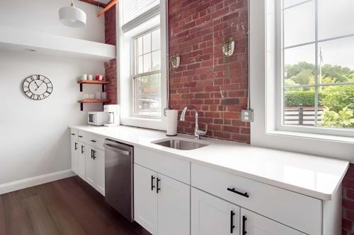 a kitchen with a sink and a brick wall at Jennifer's Historic Downtown Loft in Providence