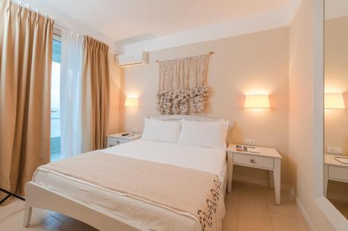a white bedroom with a bed and a window at Soleil Village & Villas in Jal