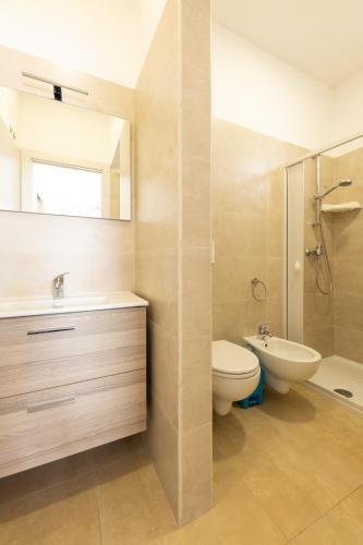 a bathroom with a toilet and a sink and a shower at Centonze appartamenti in San Foca