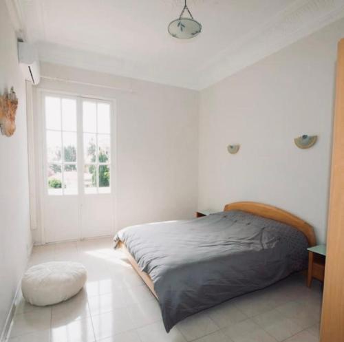 une chambre blanche avec un lit et une fenêtre dans l'établissement Villa prestigieuse avec piscine privée au cœur de Nice, à Nice