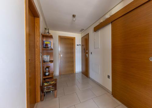 a hallway with wooden doors and a tile floor at Apart Barlovento con piscina a 10 min de la playa in Águilas