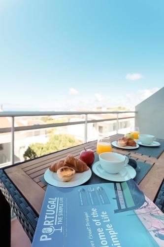 a table with two plates of breakfast food on a balcony at Serene View - By SCH in Alvados