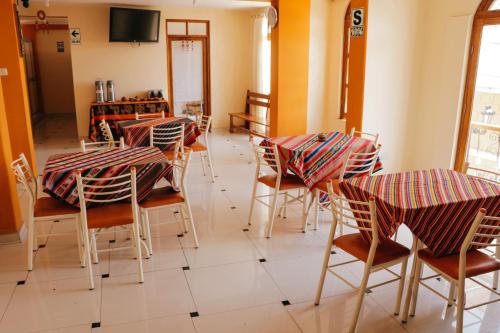 a room with tables and chairs and a television at Marlon's House Puno-Peru in Puno