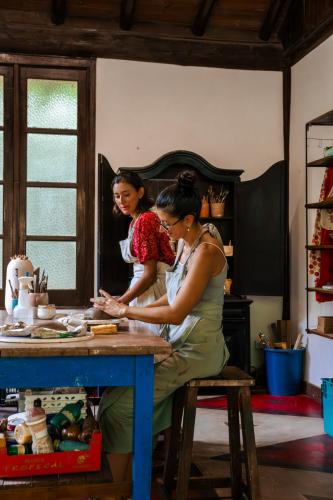 a woman and a girl preparing food in a kitchen at Atelier Arte Paraty Mirim in Paraty