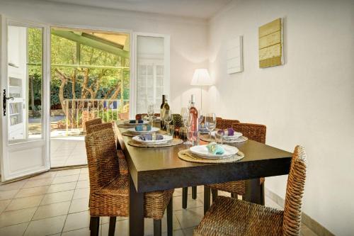 a dining room with a wooden table with chairs and a tableablish at Maison Lou Amourier - OVO Network in Cotignac