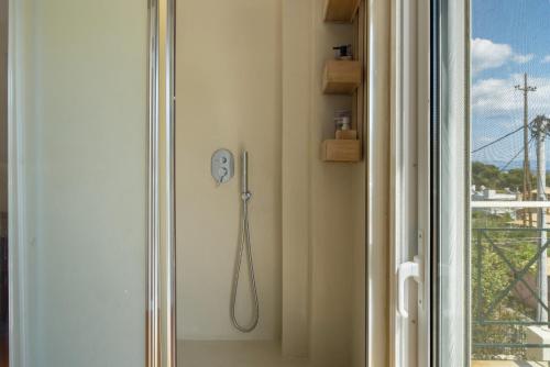 a shower in a room next to a window at Artemida Beach House in Artemida