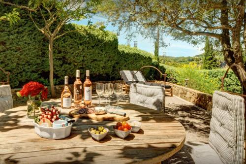 a wooden table with food and wine bottles and glasses at Maison Lou Amourier - OVO Network in Cotignac