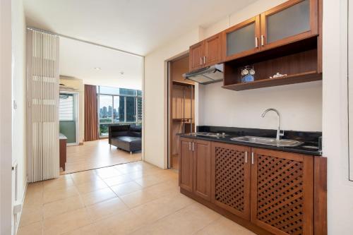 a kitchen with a sink and a living room at 181 Ekkamai Apartment in Bangkok
