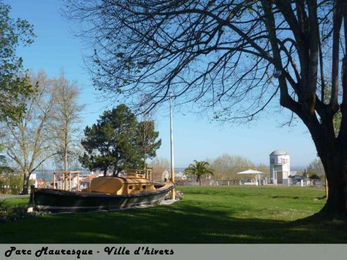 un bateau assis dans un champ à côté d'un arbre dans l'établissement T2 Centre Plage Arcachon, à Arcachon