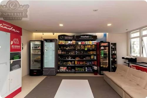a store with two refrigerators and a couch in a room at Temático,moderno e com pôr do sol Mueller/Centro in Curitiba