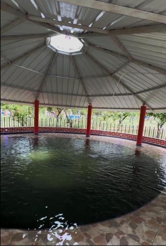 a pool of water in a pavilion with a roof at Hotel Centro vacacional El Cielo in Rivera