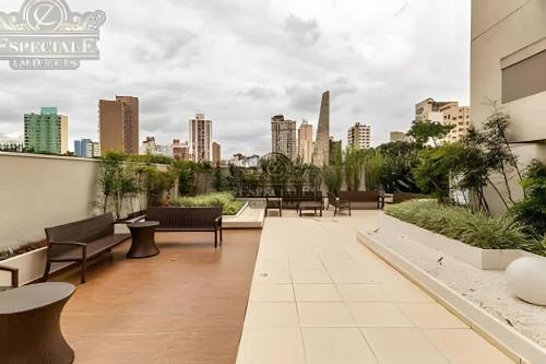 a rooftop patio with a view of the city at Temático,moderno e com pôr do sol Mueller/Centro in Curitiba