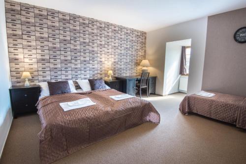 a bedroom with two beds and a brick wall at Penzion Fojtstvi in Olomouc