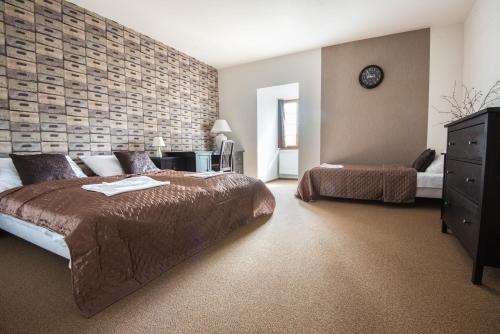 a bedroom with two beds and a brick wall at Penzion Fojtstvi in Olomouc