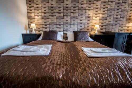 a bedroom with a large bed with two towels on it at Penzion Fojtstvi in Olomouc