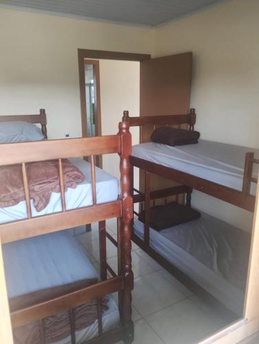 a room with three bunk beds in a room at Hostel Osoriense in Osório
