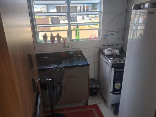 a small kitchen with a sink and a window at Hostel Osoriense in Osório