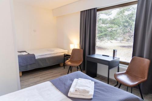 a hotel room with two beds and a window at Kiipula Guest House in Turenki
