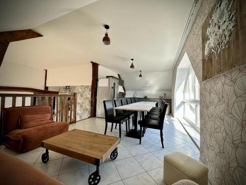 une cuisine et un salon avec une table et des chaises dans l'établissement Ecrin de Cuissai, à Cuissai
