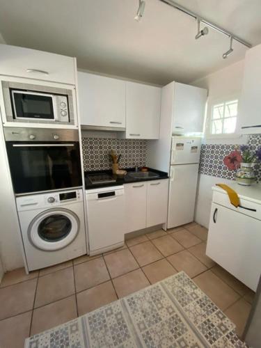 une cuisine avec un lave-linge et un micro-ondes dans l'établissement Villa Palmera, à Anglet