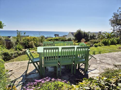 una tavola e due panche con l'oceano sullo sfondo di 730-Maison de vacances vue mer panoramique a 300m a Plouhinec