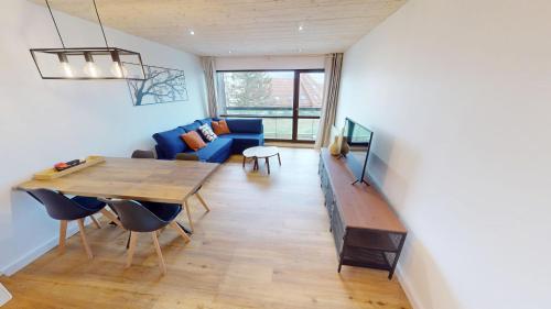 un salon avec un canapé bleu et une table dans l'établissement Appartement en plein centre, à Pontarlier